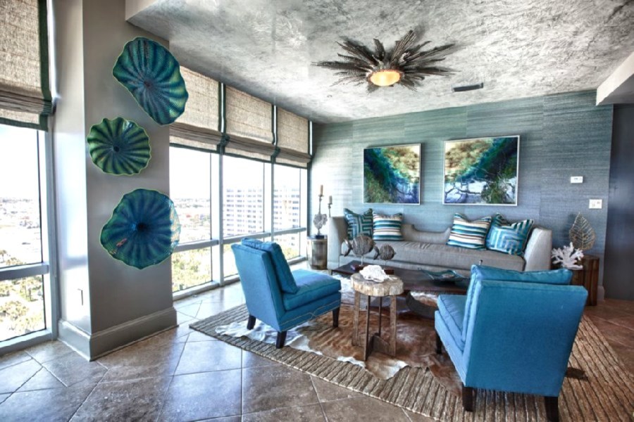 На фото: большая открытая гостиная комната в современном стиле с синими стенами, полом из керамической плитки и телевизором на стене
