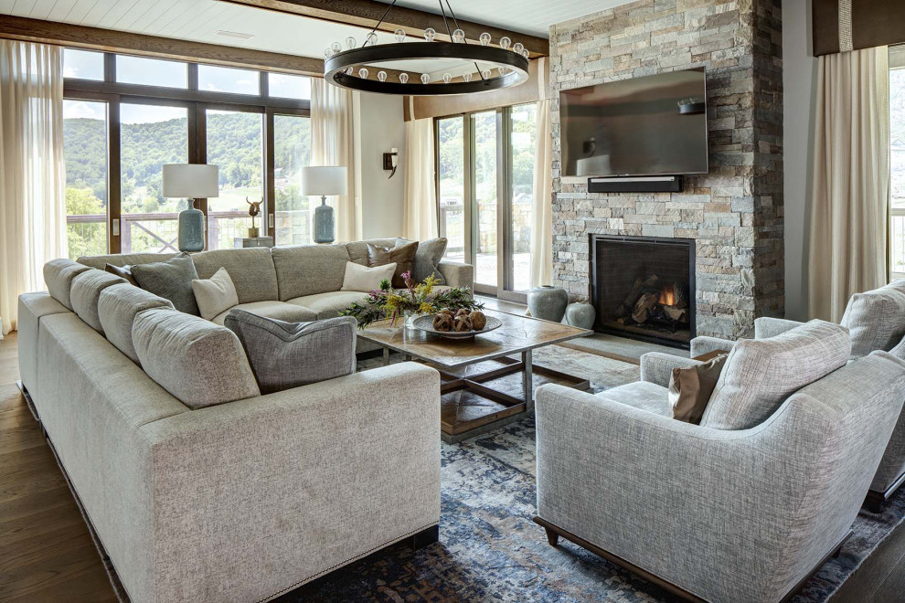 Mountain style dark wood floor, brown floor and exposed beam living room photo in New York with white walls, a standard fireplace, a stone fireplace and a wall-mounted tv