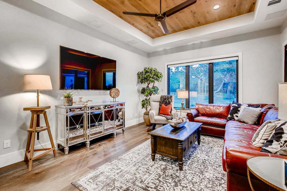 Photo of a medium sized contemporary enclosed living room in Austin with a music area, white walls, medium hardwood flooring, no fireplace, a wall mounted tv and brown floors.