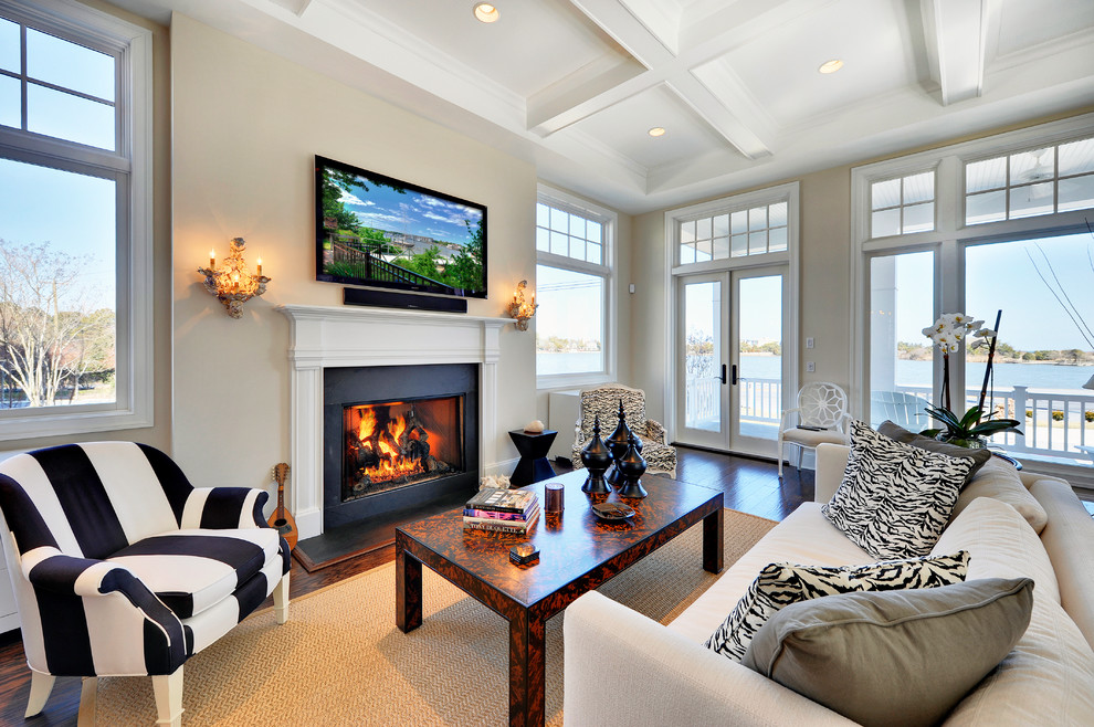 На фото: гостиная комната в классическом стиле с стандартным камином, телевизором на стене и коричневым полом с