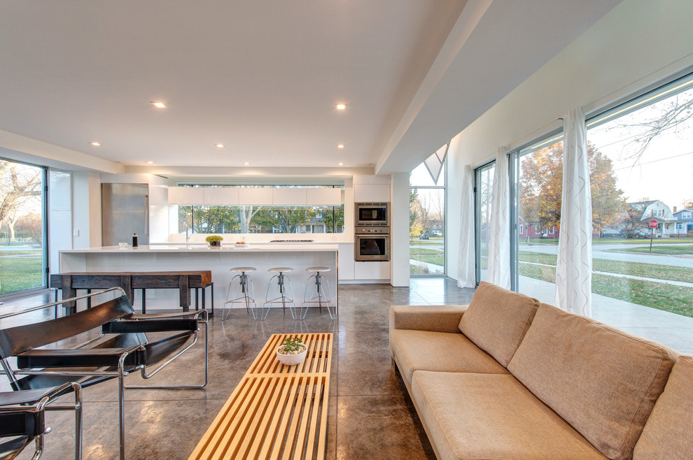 Immagine di un soggiorno minimalista aperto con pareti bianche, pavimento in cemento, nessun camino e pavimento grigio