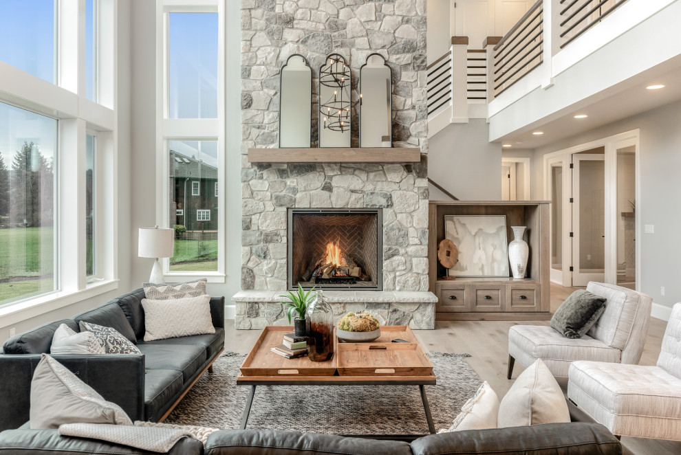 Large transitional open concept light wood floor and gray floor living room photo in Portland with gray walls, a standard fireplace and a stone fireplace