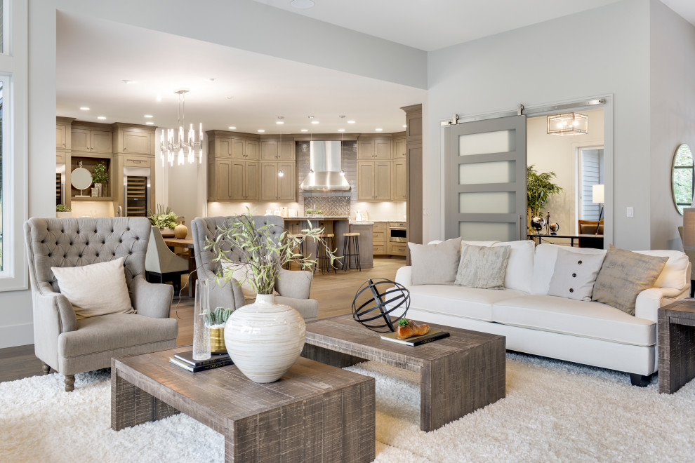 Large classic open plan living room in Portland with grey walls, medium hardwood flooring, a metal fireplace surround and beige floors.