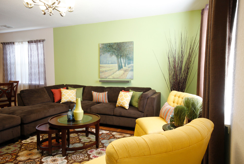 Example of a mid-sized trendy open concept medium tone wood floor living room design in Houston with green walls