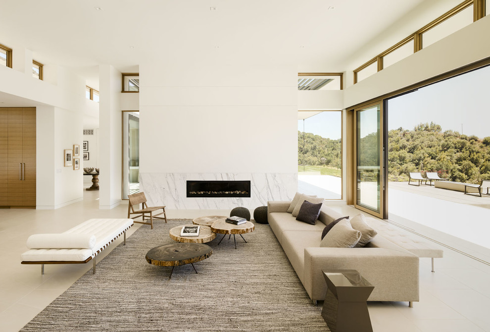 На фото: открытая гостиная комната в современном стиле с белыми стенами, горизонтальным камином и ковром на полу с