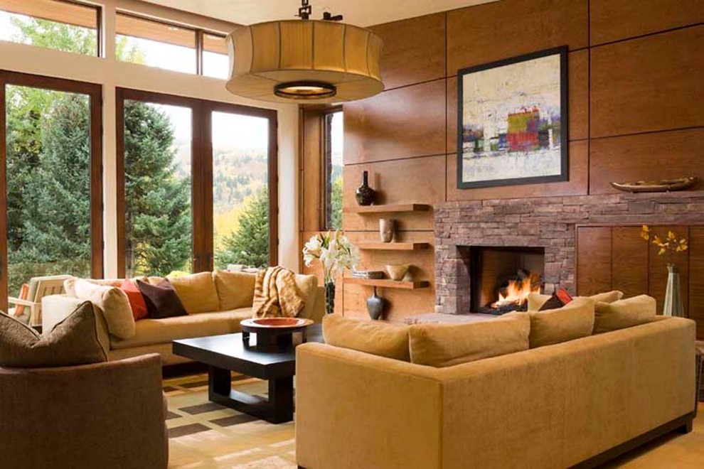 Mittelgroßes, Repräsentatives, Offenes Modernes Wohnzimmer mit brauner Wandfarbe, braunem Holzboden, Kamin, Kaminumrandung aus Stein und Multimediawand in Denver