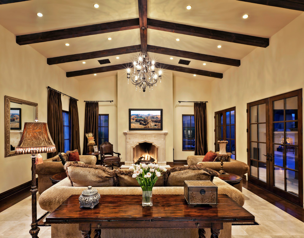 Großes, Repräsentatives, Offenes Mediterranes Wohnzimmer mit beiger Wandfarbe, Kamin, TV-Wand, Keramikboden und beigem Boden in Phoenix