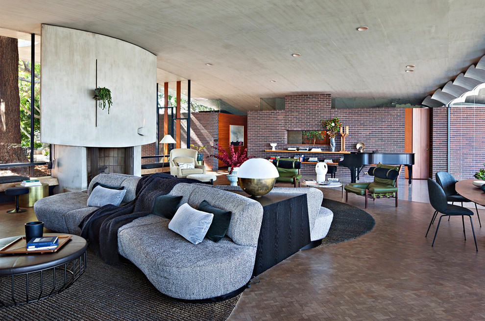 Идея дизайна: открытая гостиная комната в стиле ретро с фасадом камина из бетона и коричневым полом