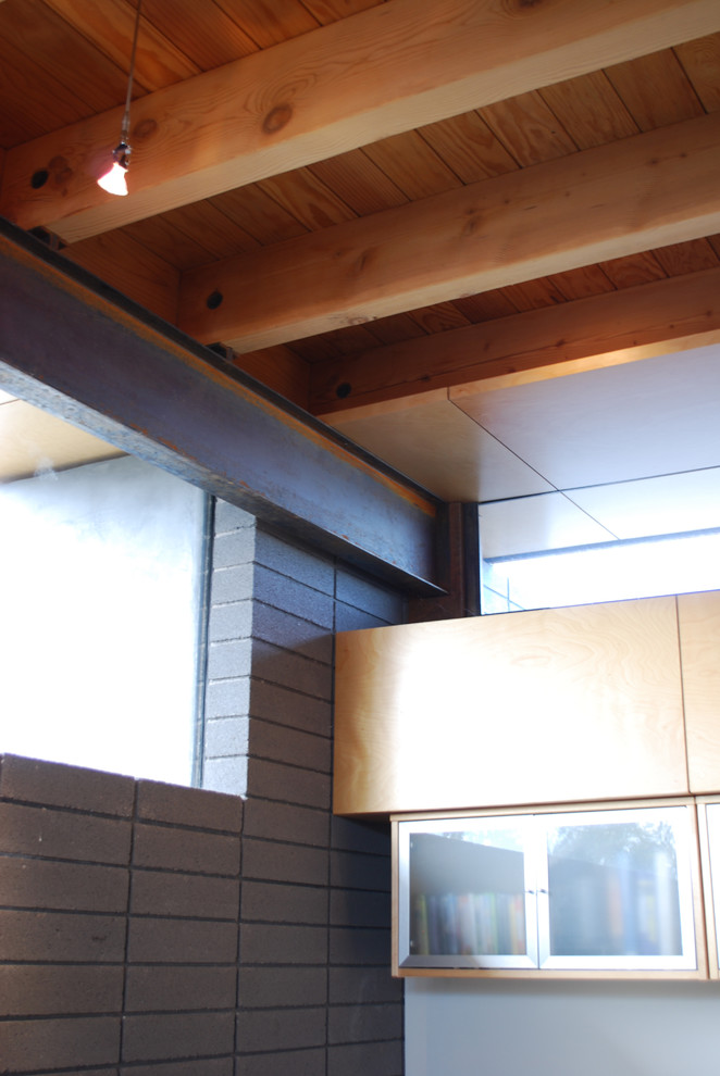 Kleines, Offenes Modernes Wohnzimmer mit grauer Wandfarbe, Betonboden, Tunnelkamin und Kaminumrandung aus Beton in Phoenix
