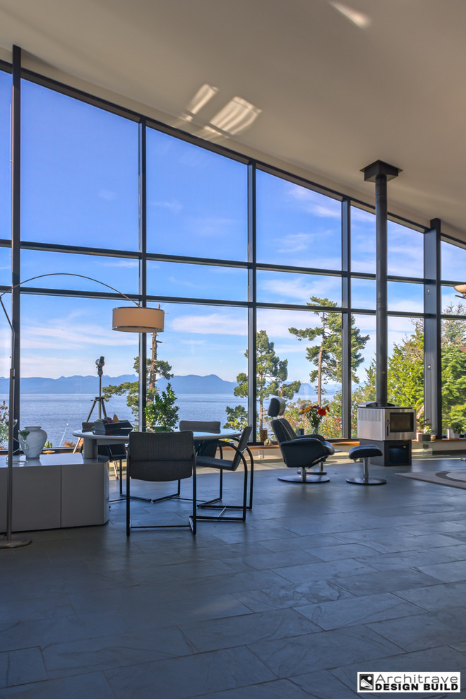 Großes, Fernseherloses, Offenes Modernes Wohnzimmer mit weißer Wandfarbe, Schieferboden, Hängekamin und Kaminumrandung aus Metall in Vancouver