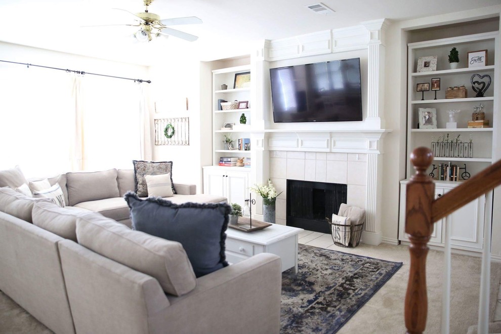 Стильный дизайн: открытая гостиная комната среднего размера в классическом стиле с белыми стенами, ковровым покрытием, стандартным камином, фасадом камина из дерева, телевизором на стене и бежевым полом - последний тренд