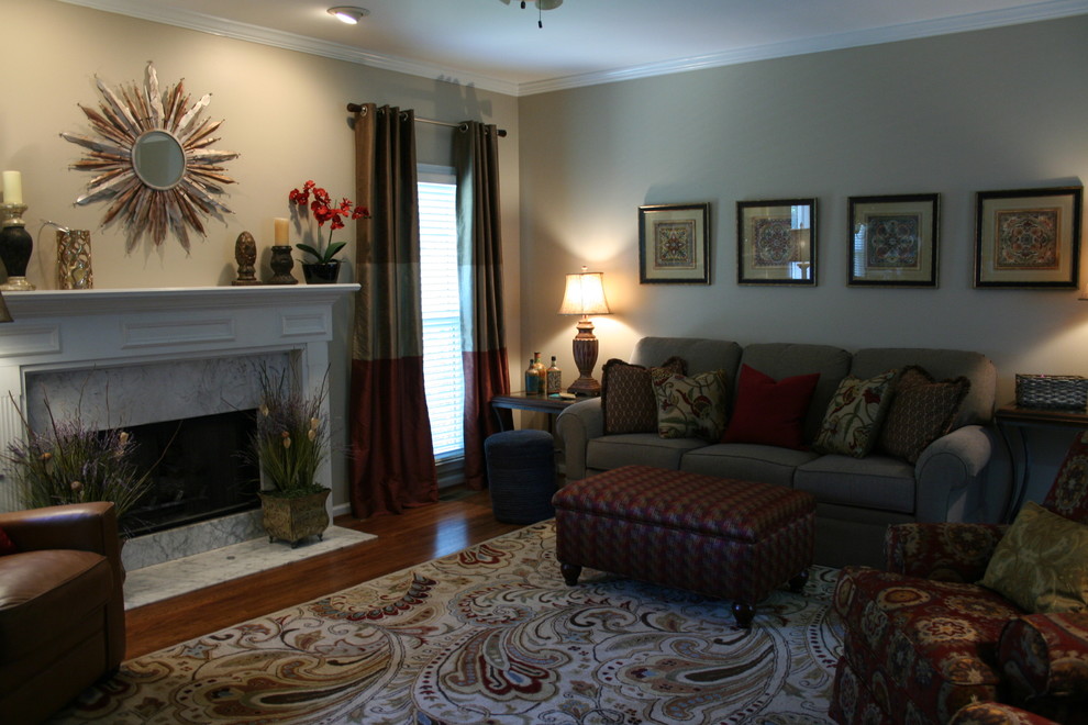 Example of a mid-sized transitional medium tone wood floor living room design in Atlanta with beige walls, a standard fireplace, a stone fireplace and a tv stand