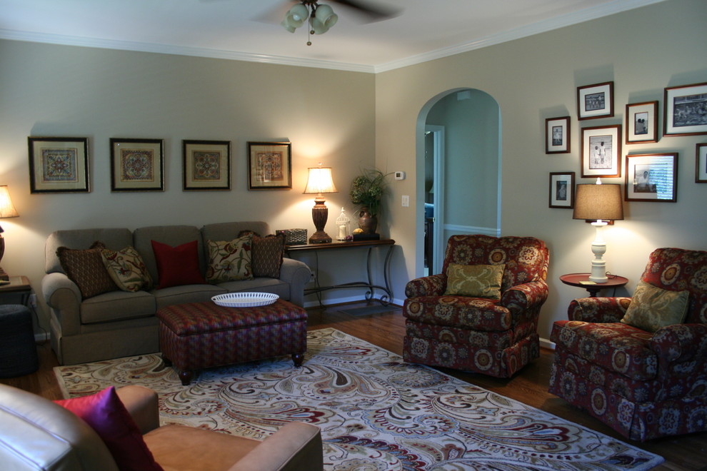 Exempel på ett mellanstort klassiskt vardagsrum, med beige väggar, mellanmörkt trägolv, en standard öppen spis, en spiselkrans i sten och en fristående TV