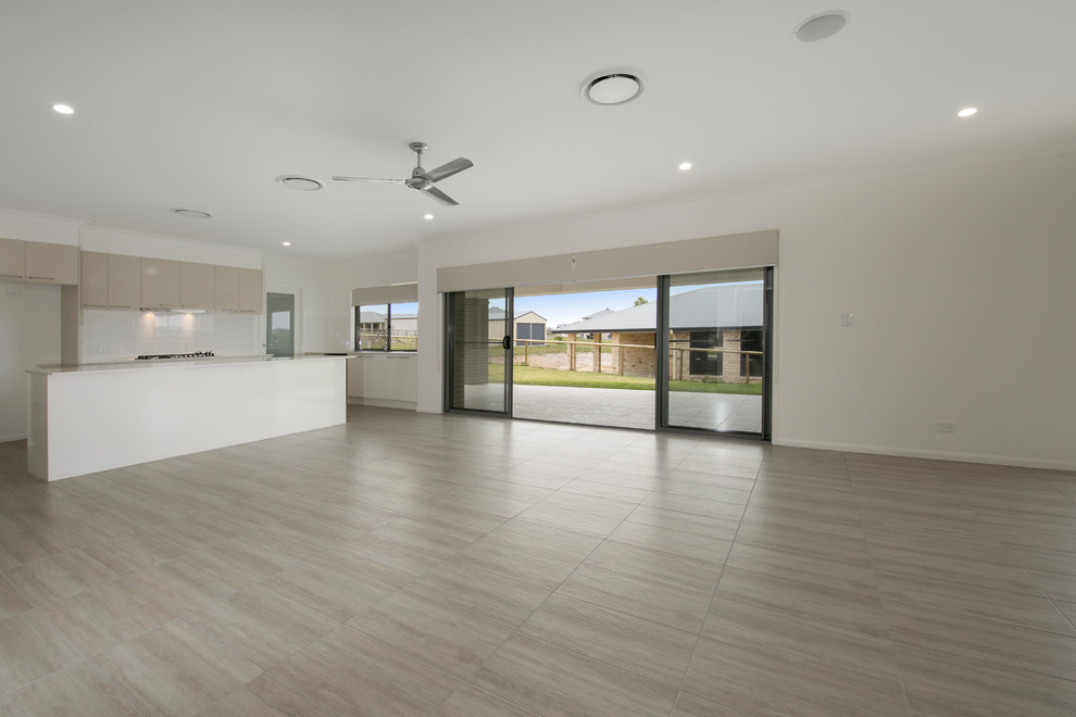 This is an example of an expansive modern open plan living room in Brisbane with white walls, ceramic flooring and brown floors.