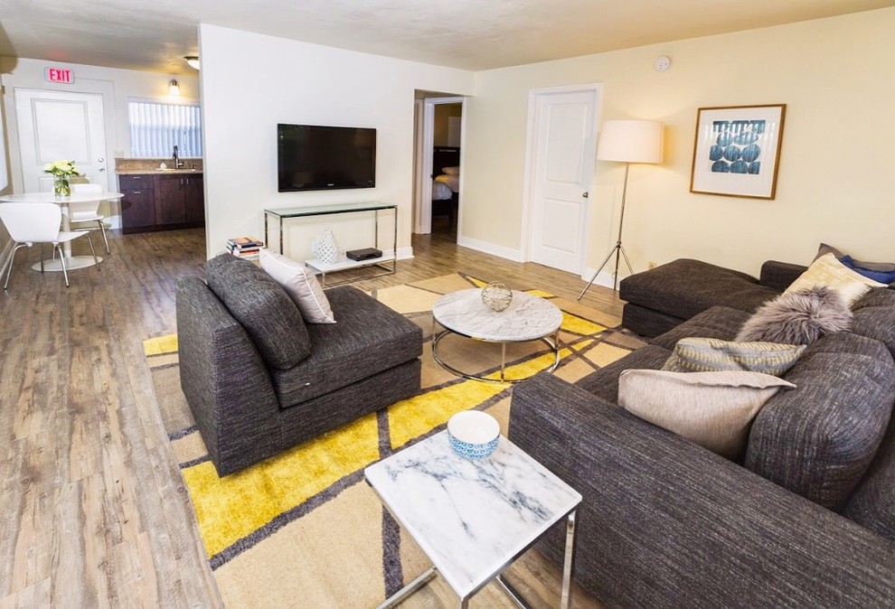Immagine di un soggiorno classico di medie dimensioni con pareti beige, pavimento con piastrelle in ceramica, nessun camino, TV a parete e pavimento marrone