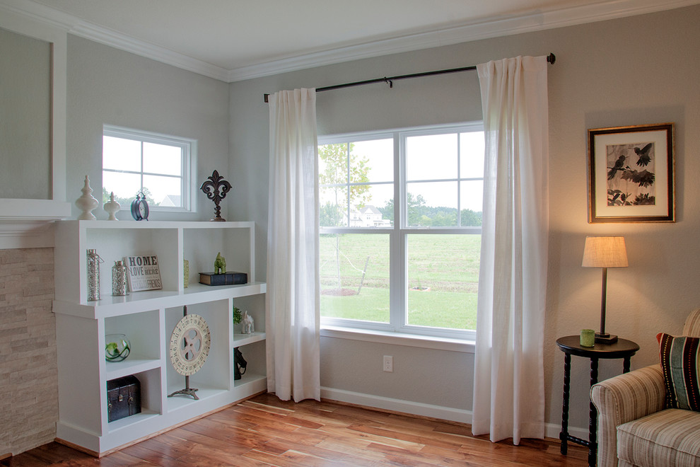 Foto di un soggiorno minimalista con pareti grigie e pavimento marrone