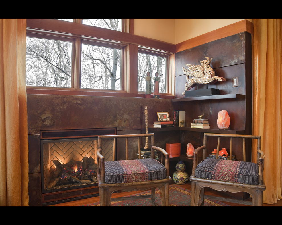 Cette image montre un grand salon bohème ouvert avec un sol en bois brun, une cheminée standard, un manteau de cheminée en métal et aucun téléviseur.