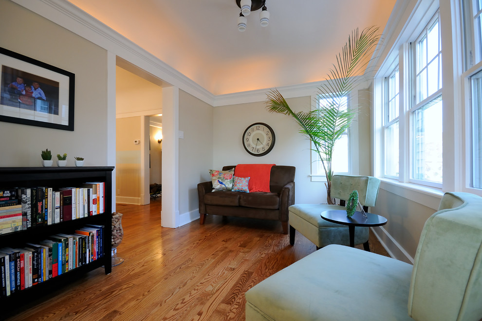 Aménagement d'un salon classique avec un mur beige et un sol en bois brun.
