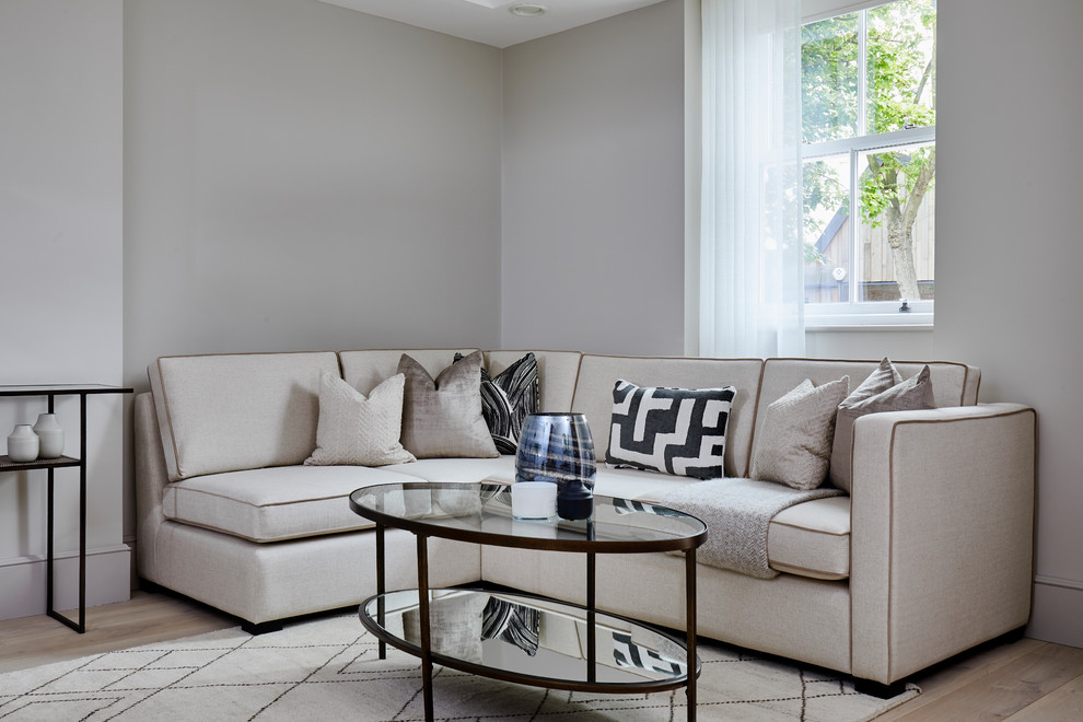 Immagine di un soggiorno classico con pareti grigie, parquet chiaro e nessun camino