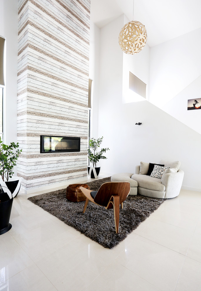 Идея дизайна: открытая гостиная комната среднего размера в современном стиле с белыми стенами, полом из керамогранита, стандартным камином и фасадом камина из штукатурки без телевизора