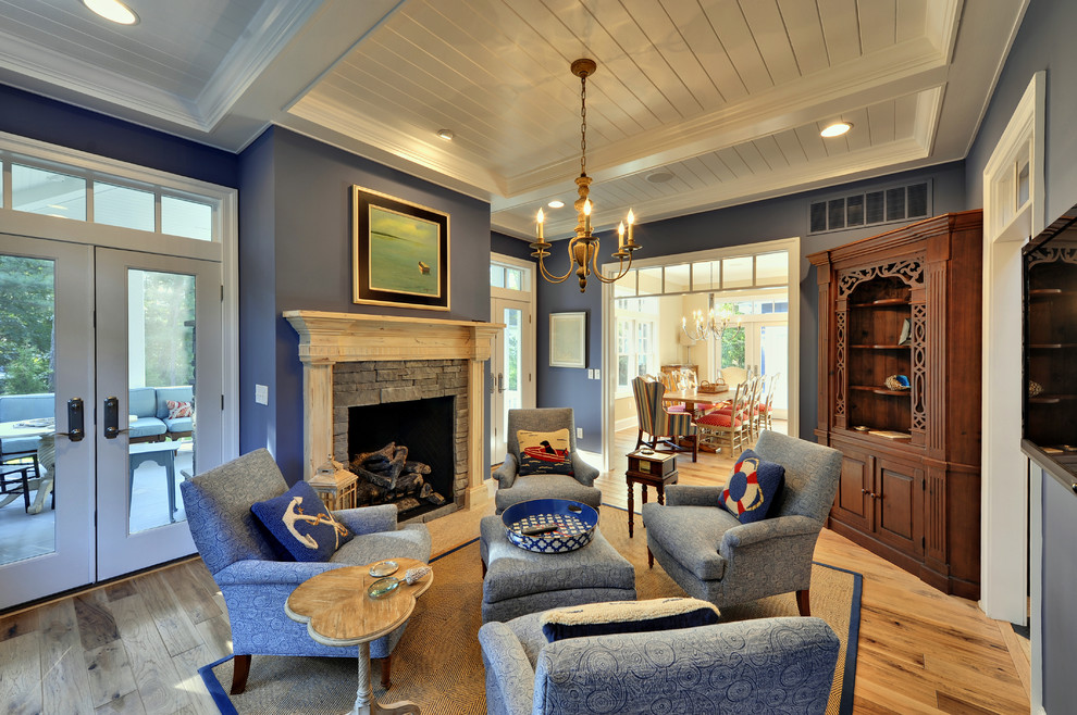 На фото: гостиная комната в морском стиле с синими стенами и бежевым полом с