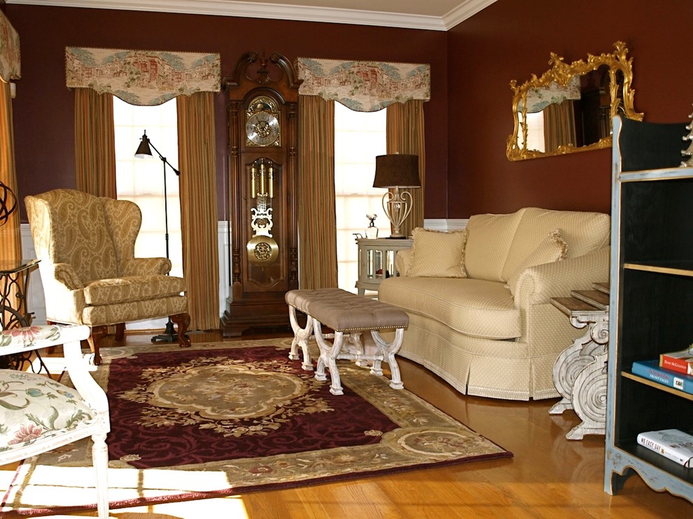 Ispirazione per un soggiorno classico con libreria, pareti rosse e pavimento in legno massello medio