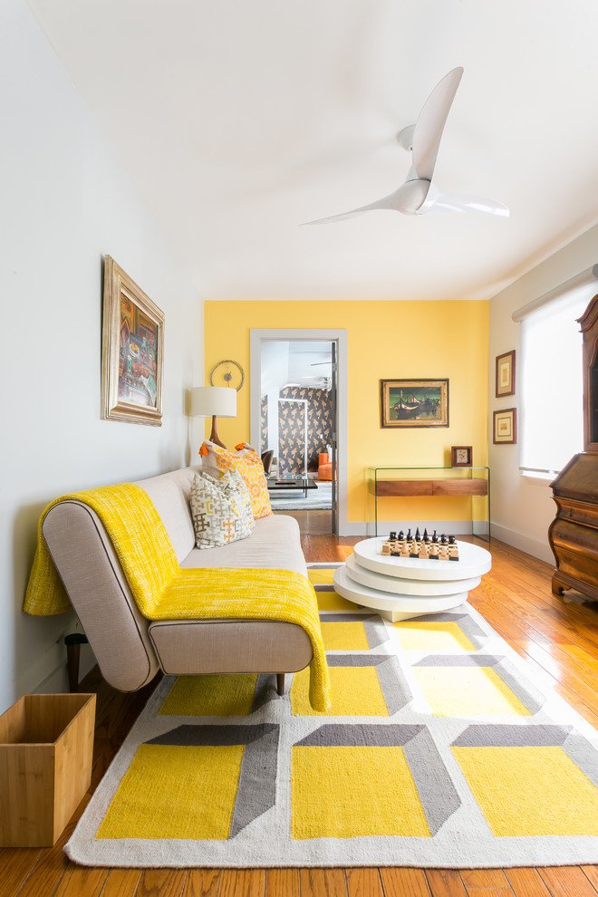 Mittelgroßes, Repräsentatives, Fernseherloses, Offenes Stilmix Wohnzimmer ohne Kamin mit gelber Wandfarbe, braunem Holzboden und braunem Boden in Charleston