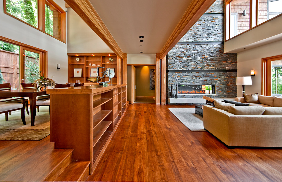 Идея дизайна: огромная открытая гостиная комната в современном стиле с бежевыми стенами, паркетным полом среднего тона, горизонтальным камином и фасадом камина из камня