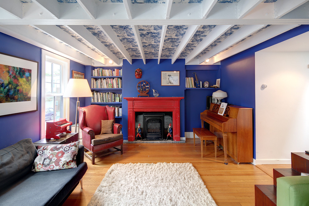 Inspiration för ett litet vintage separat vardagsrum, med en standard öppen spis, en spiselkrans i trä, ett musikrum, blå väggar, ljust trägolv och beiget golv
