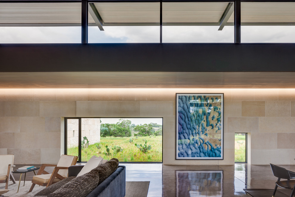 Offenes Modernes Wohnzimmer mit beiger Wandfarbe und Betonboden in Austin