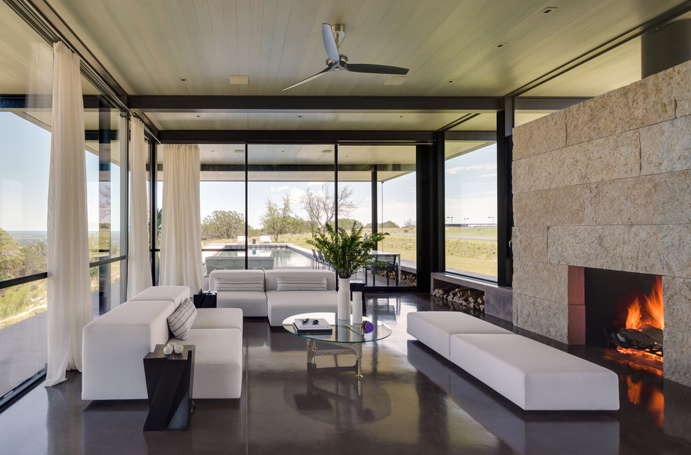Repräsentatives Modernes Wohnzimmer mit Betonboden, Kamin und Kaminumrandung aus Stein in Austin