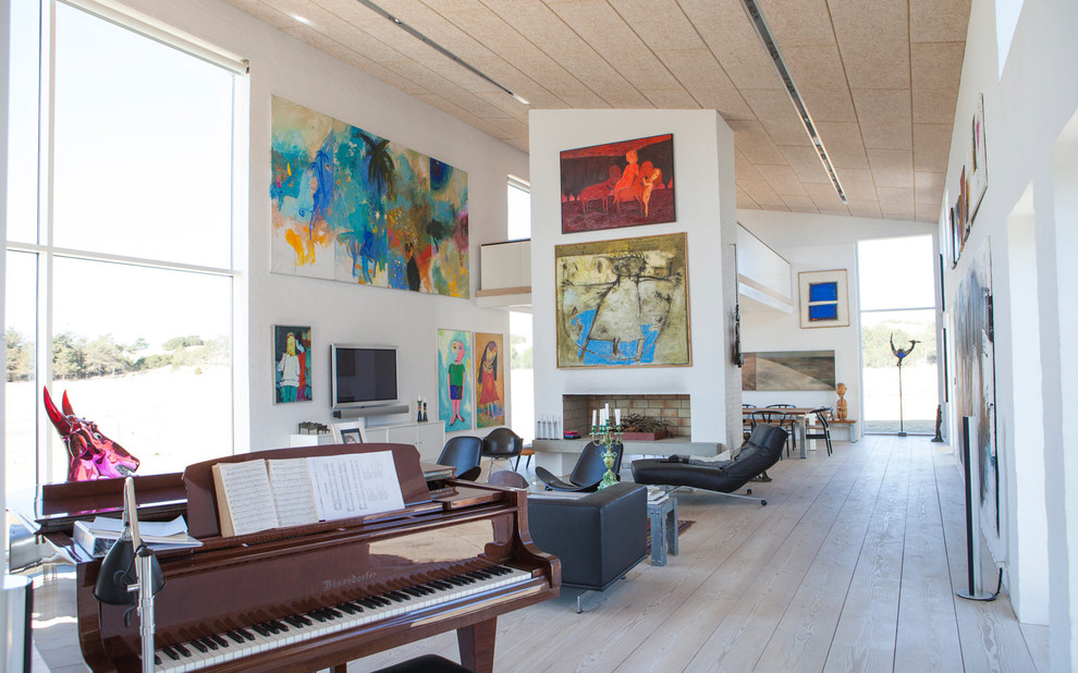 Стильный дизайн: большая парадная, открытая гостиная комната в скандинавском стиле с белыми стенами, светлым паркетным полом, горизонтальным камином, фасадом камина из кирпича и телевизором на стене - последний тренд