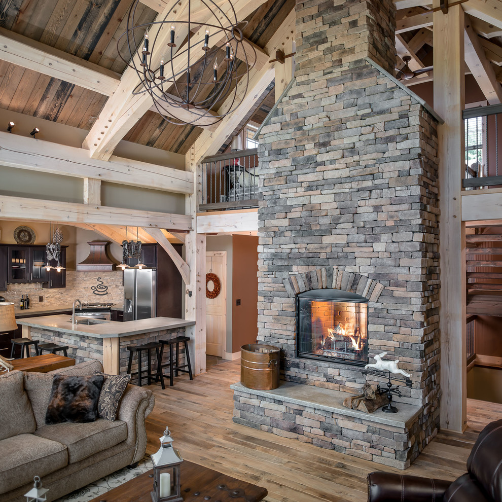 Example of a large mountain style open concept medium tone wood floor and brown floor living room design in Atlanta with gray walls, a standard fireplace and a stone fireplace