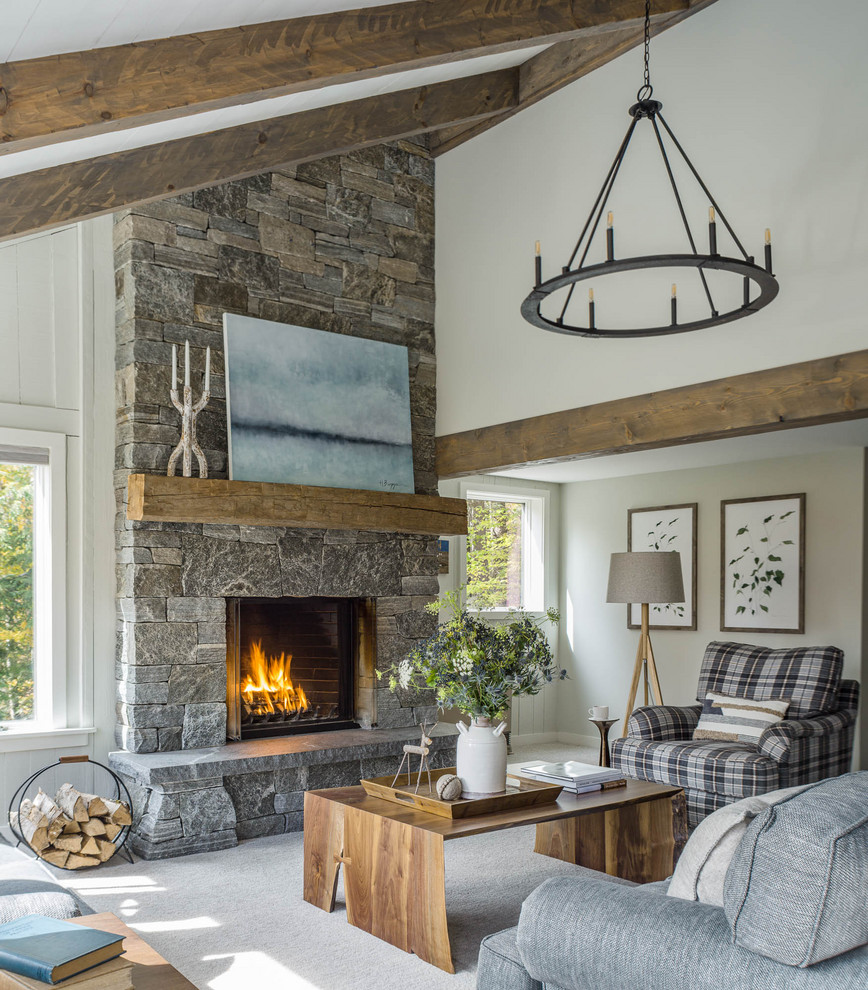 Rustic open plan living room in Burlington with white walls, carpet, a standard fireplace and grey floors.