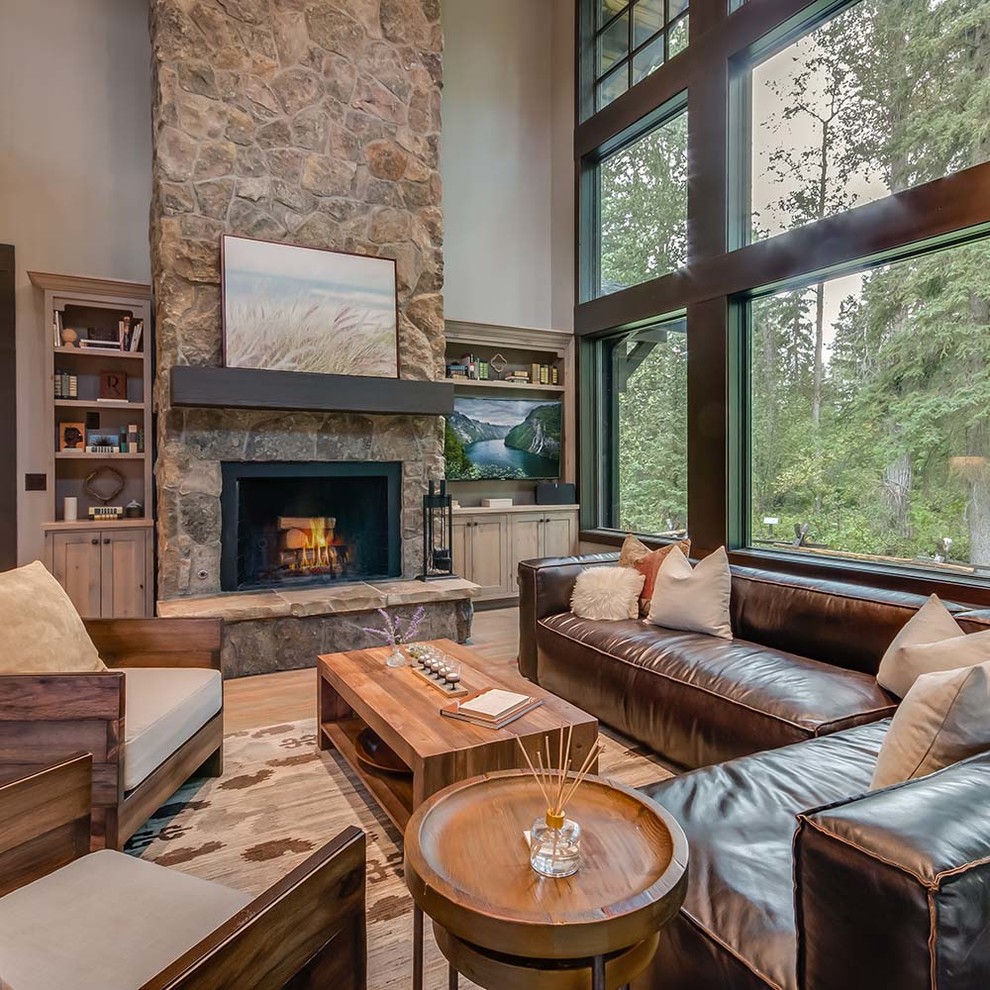 Inspiration for a mid-sized rustic open concept and formal medium tone wood floor and brown floor living room remodel in Other with gray walls, a standard fireplace, a stone fireplace and a wall-mounted tv