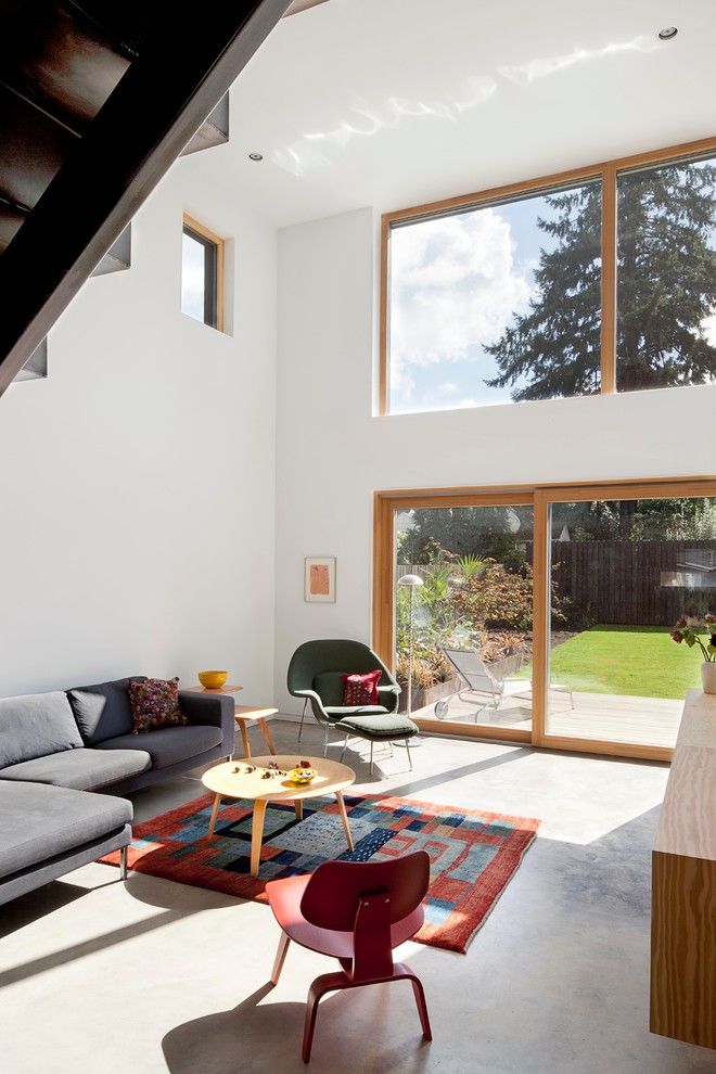 Offenes Modernes Wohnzimmer mit weißer Wandfarbe und Betonboden in Portland