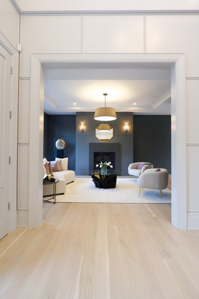 Großes, Repräsentatives, Fernseherloses, Abgetrenntes Modernes Wohnzimmer mit grauer Wandfarbe, hellem Holzboden, Kamin und braunem Boden in New York