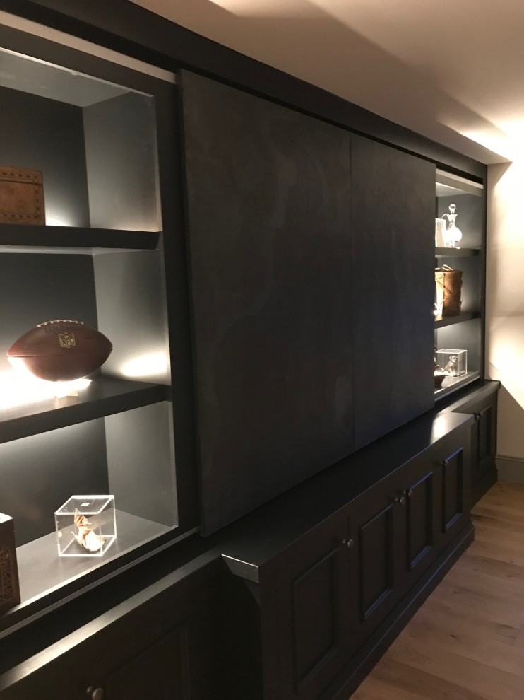 Ejemplo de salón con barra de bar cerrado tradicional renovado grande con paredes grises, suelo de madera en tonos medios y pared multimedia