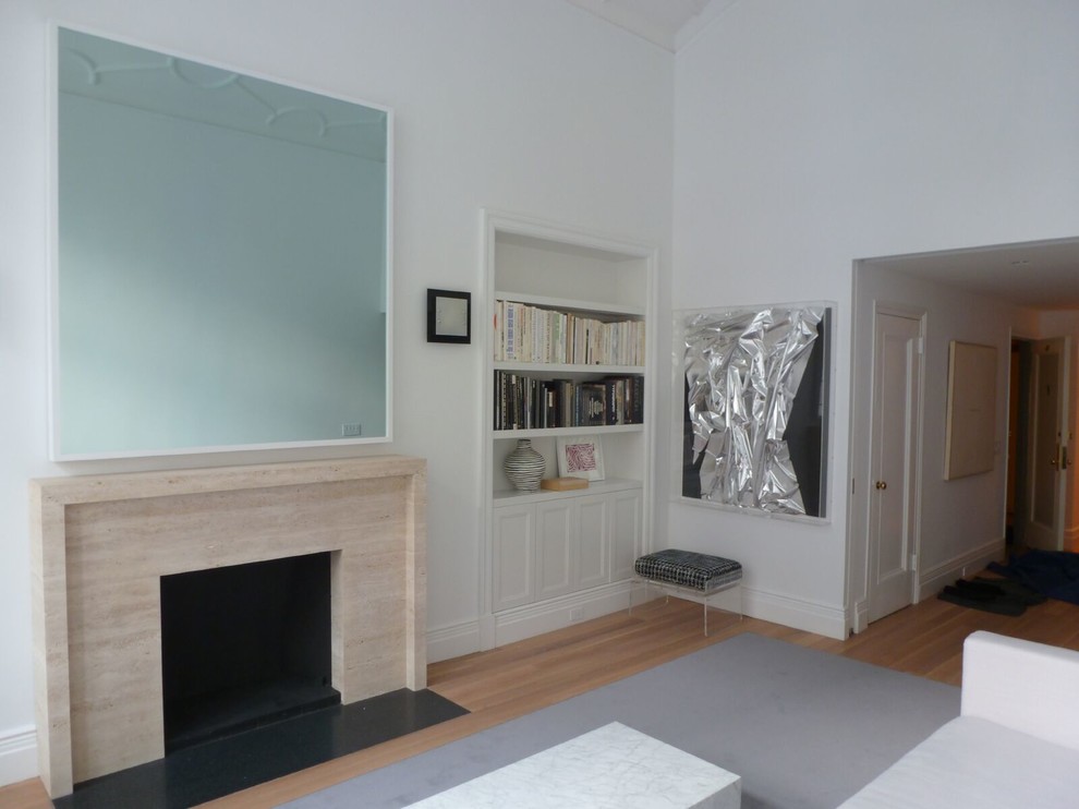 Modernes Wohnzimmer mit Kaminumrandung aus Stein und verstecktem TV in New York