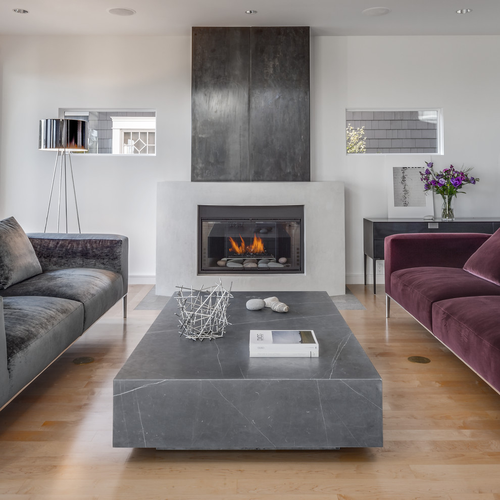 Photo of a medium sized contemporary open plan living room in Seattle with white walls, light hardwood flooring, a standard fireplace and a concrete fireplace surround.