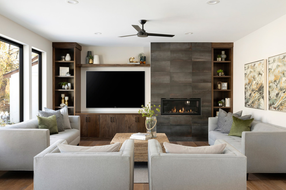 Exempel på ett mellanstort modernt allrum med öppen planlösning, med grå väggar, mellanmörkt trägolv, en bred öppen spis, en spiselkrans i trä, en väggmonterad TV, brunt golv och ett finrum