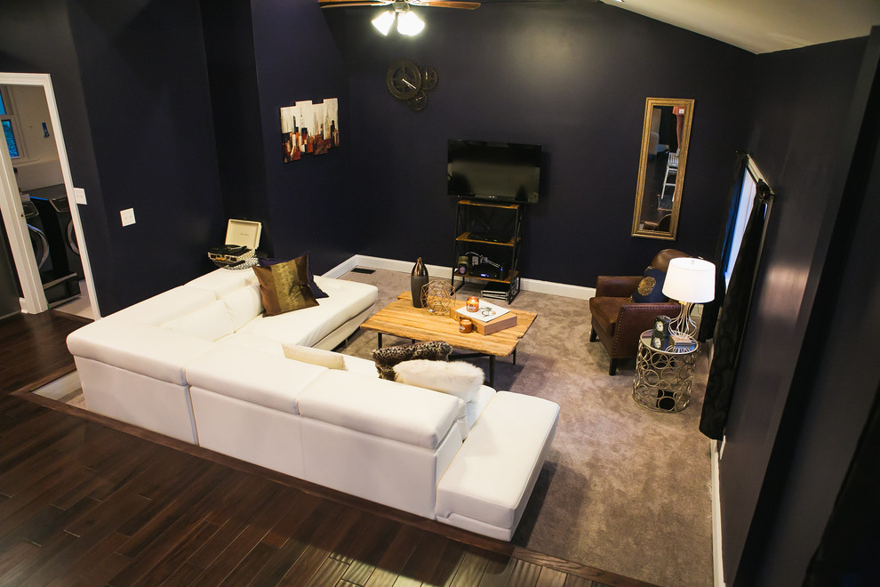 Immagine di un soggiorno boho chic di medie dimensioni e aperto con pareti blu, parquet scuro e TV a parete