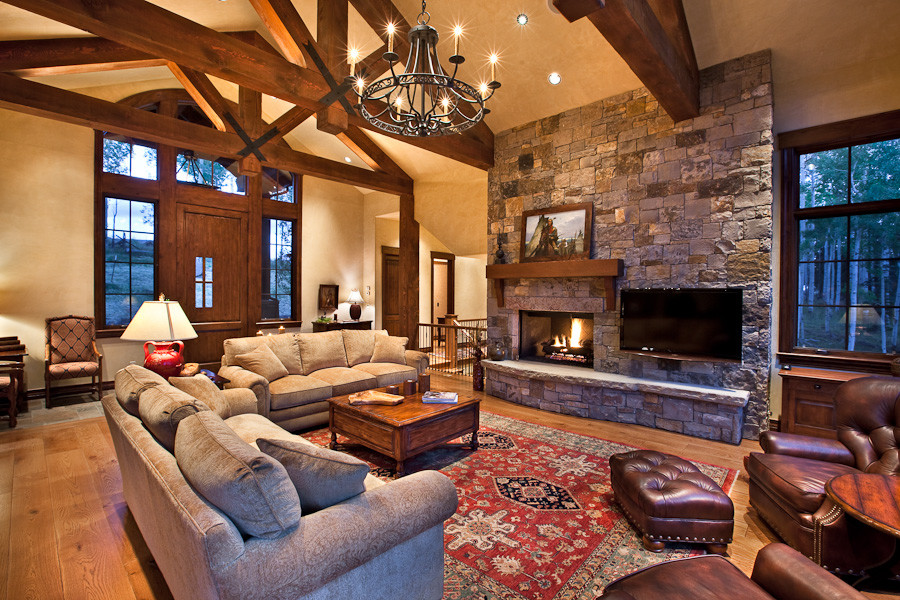 Design ideas for a rustic open plan living room in Denver with beige walls, light hardwood flooring, a standard fireplace, a stone fireplace surround and a wall mounted tv.