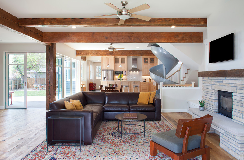 Offenes Modernes Wohnzimmer mit weißer Wandfarbe, hellem Holzboden, Kamin, Kaminumrandung aus Stein und TV-Wand in Denver