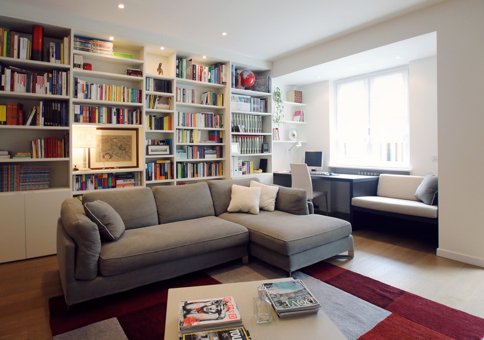 Ispirazione per un soggiorno design di medie dimensioni e aperto con libreria, pareti bianche e pavimento in legno massello medio