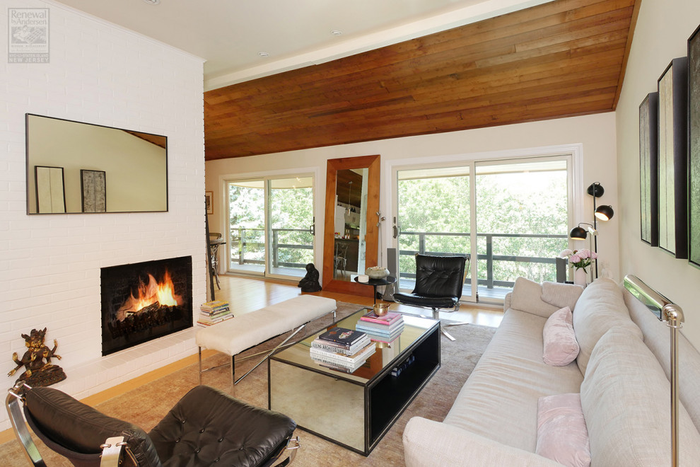 Mid-sized formal and open concept light wood floor, beige floor and shiplap ceiling living room photo in Newark with white walls, a standard fireplace, a brick fireplace and no tv