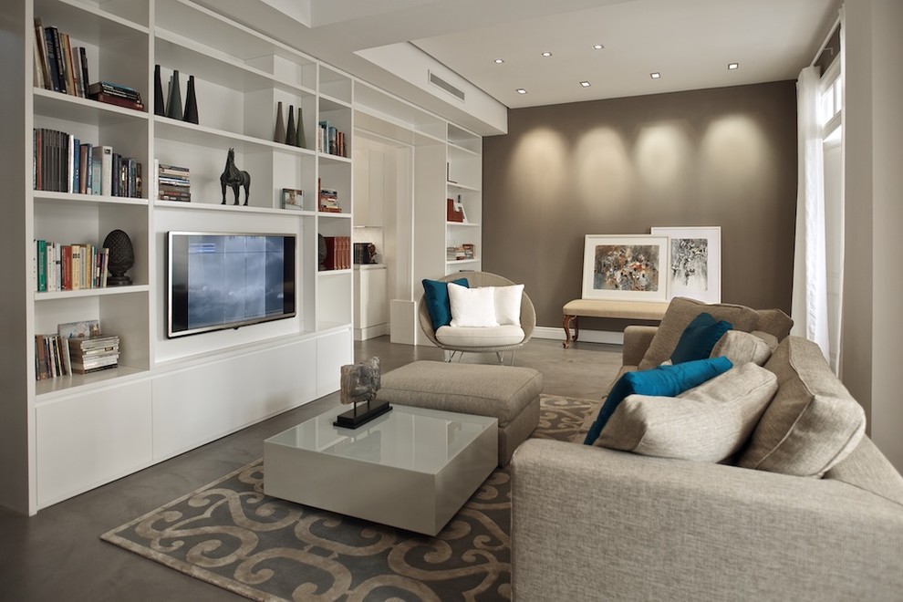 Свежая идея для дизайна: гостиная комната среднего размера в стиле фьюжн с с книжными шкафами и полками, коричневыми стенами, бетонным полом и телевизором на стене - отличное фото интерьера