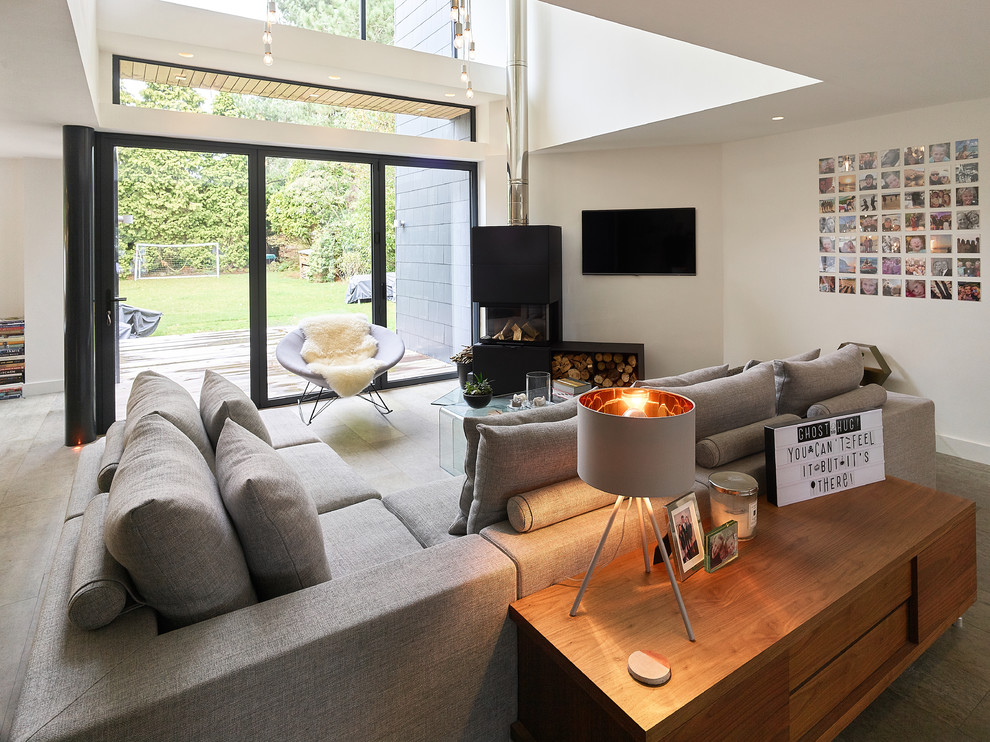 Modernes Wohnzimmer mit weißer Wandfarbe, Tunnelkamin, TV-Wand und grauem Boden in West Midlands