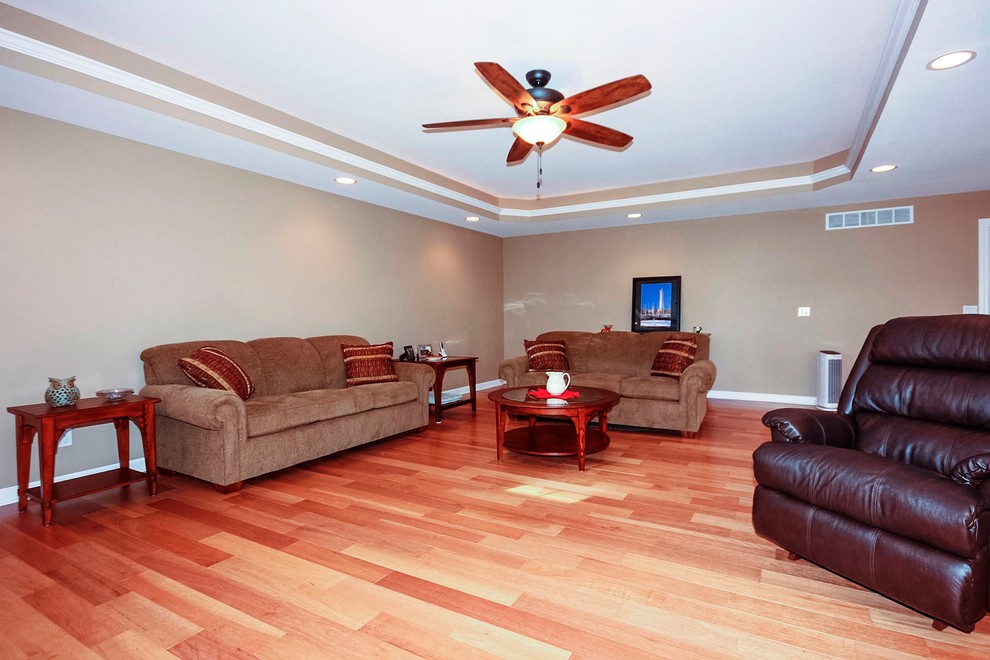 Kleines, Offenes Klassisches Wohnzimmer mit beiger Wandfarbe, braunem Holzboden, Kamin, gefliester Kaminumrandung und TV-Wand in Chicago