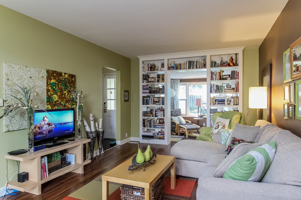 Стильный дизайн: открытая гостиная комната среднего размера в стиле фьюжн с зелеными стенами, темным паркетным полом и отдельно стоящим телевизором без камина - последний тренд